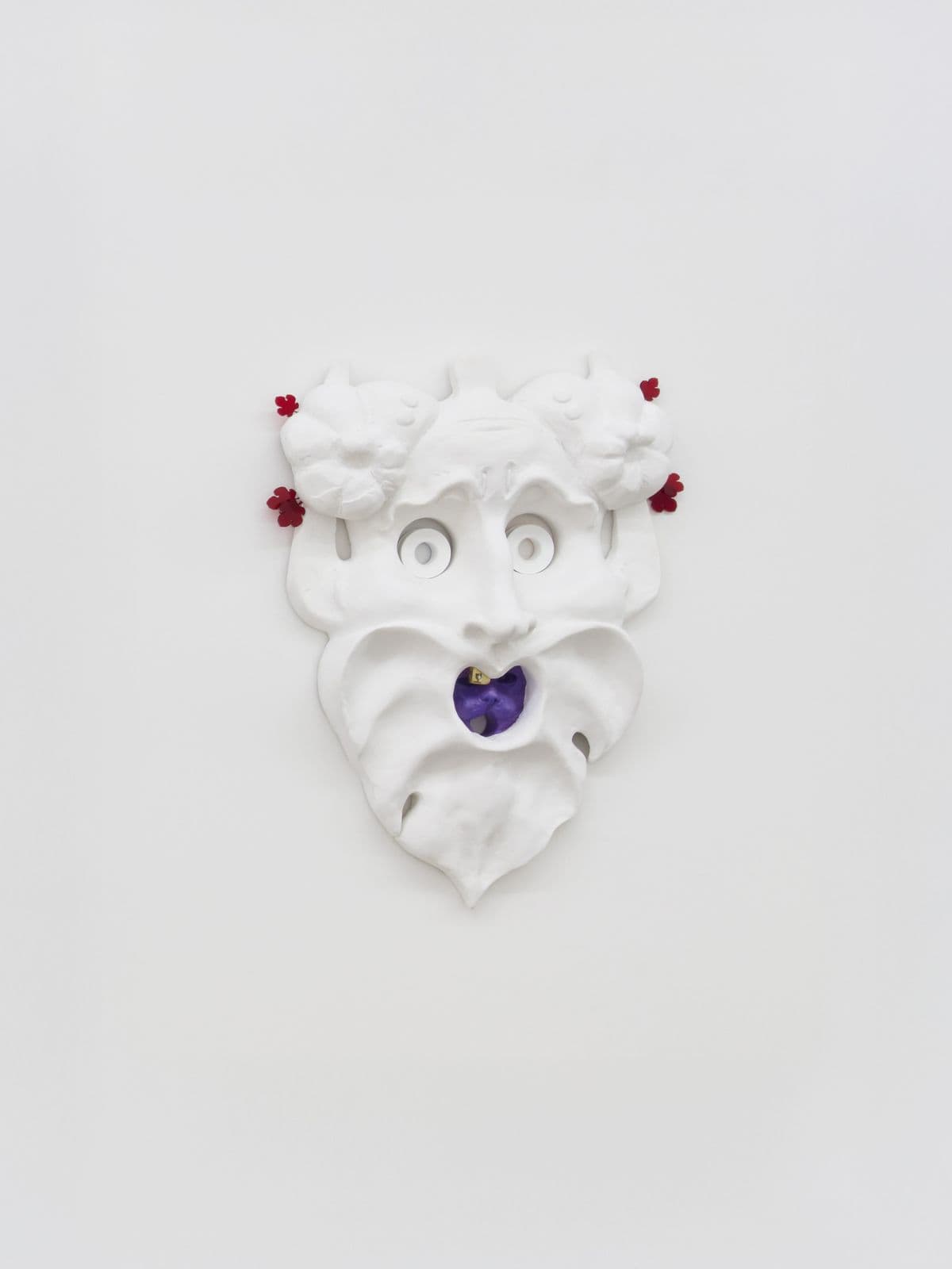 Oral Tradition III, white satyr-inspired mask sculpture by Grigorios Ilaridis with serpent-like eyebrows, a single gold tooth and a hidden purple cat inside the open mouth.